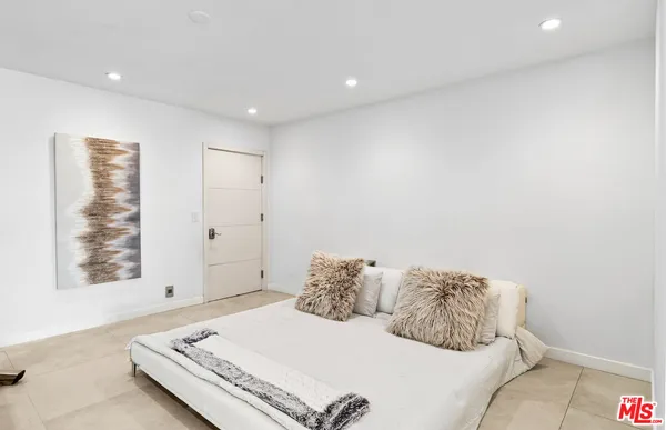 a bedroom with bed and a book shelf