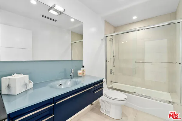a bathroom with a double vanity sink toilet and shower