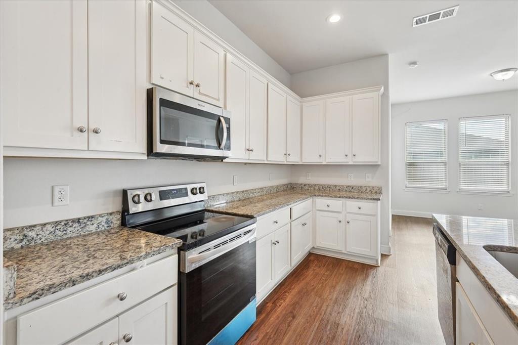 313 Marble Creek Drive Fort Worth, TX 76131 - Photo 10 of 27 a kitchen with granite countertop cabinets stainless steel appliances and a wooden floor
