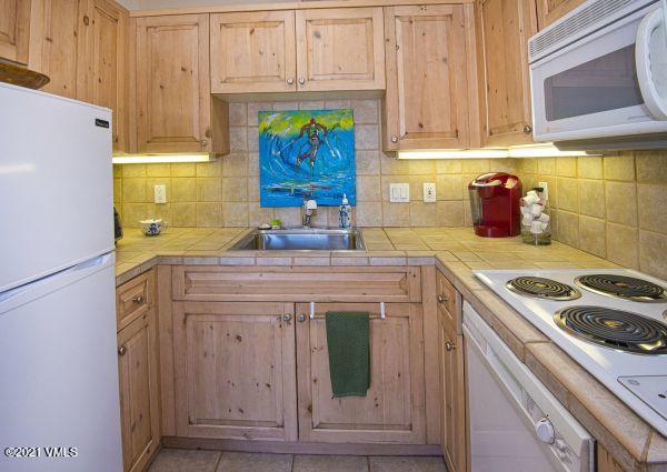 225 Wall Street, Unit 302 Vail, CO 81657 - Photo 11 of 19 a kitchen with stainless steel appliances granite countertop a sink stove and cabinets