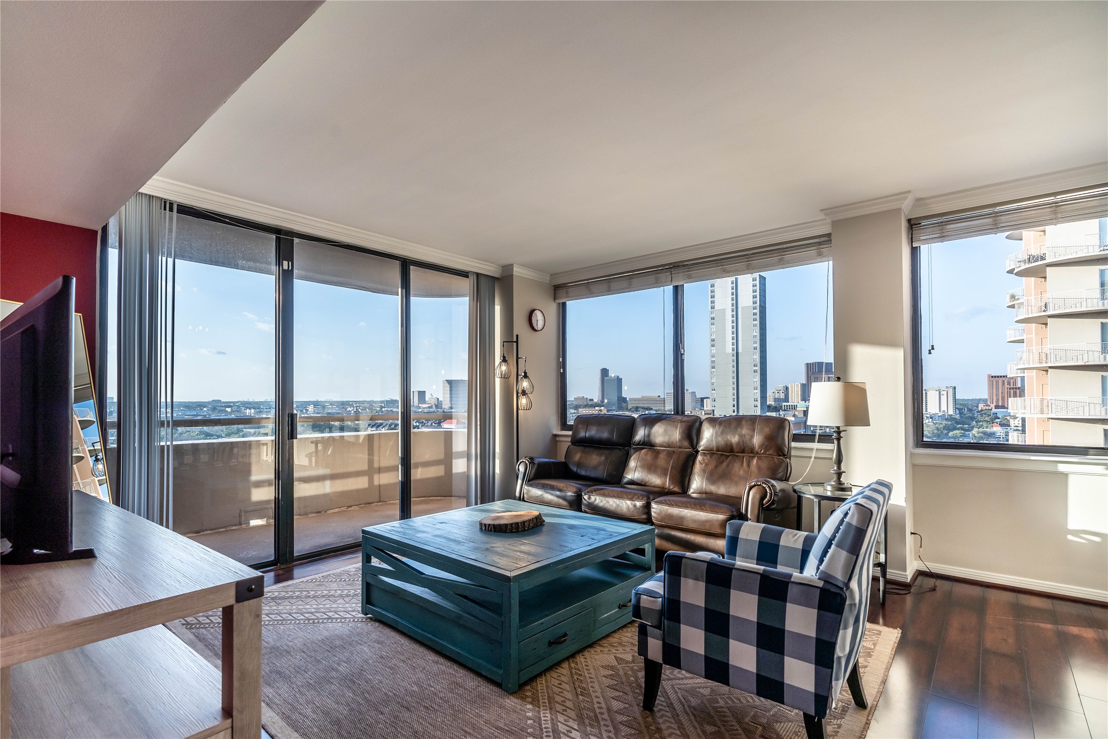 3525 Sage Road, Unit 1315 Houston, TX 77056 - Photo 2 of 20 a living room with furniture a flat screen tv and a floor to ceiling window