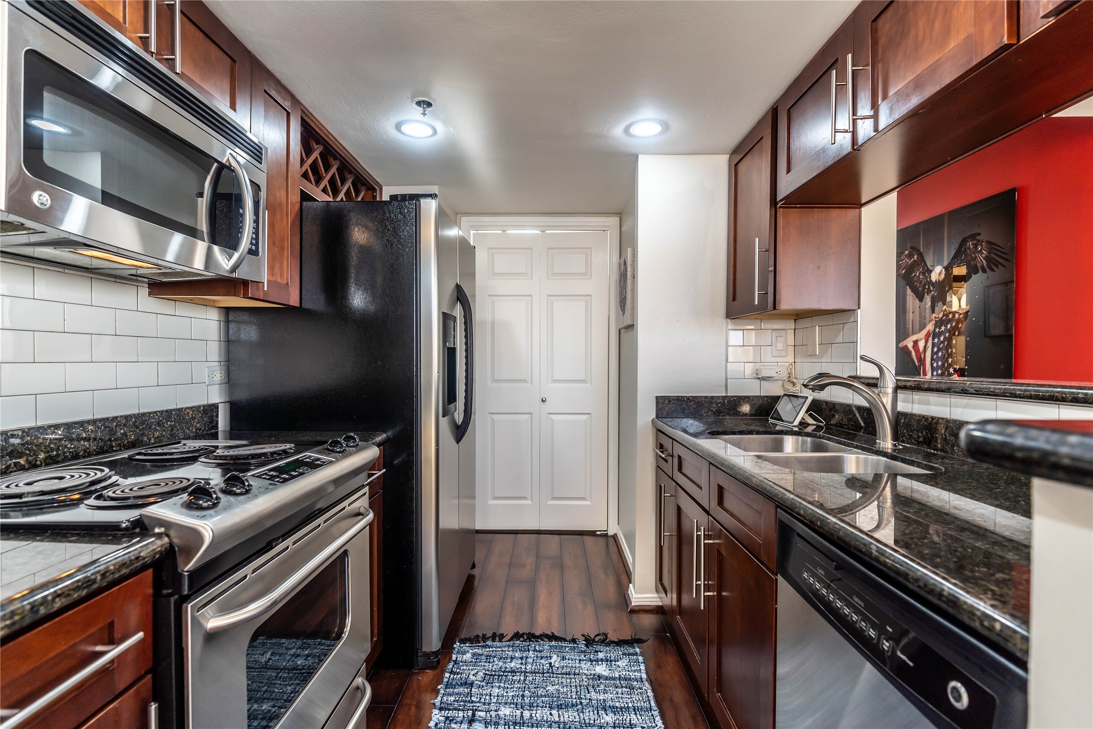 3525 Sage Road, Unit 1315 Houston, TX 77056 - Photo 6 of 20 a kitchen with stainless steel appliances granite countertop a stove and a microwave