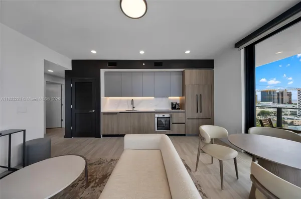 a living room with furniture and a kitchen