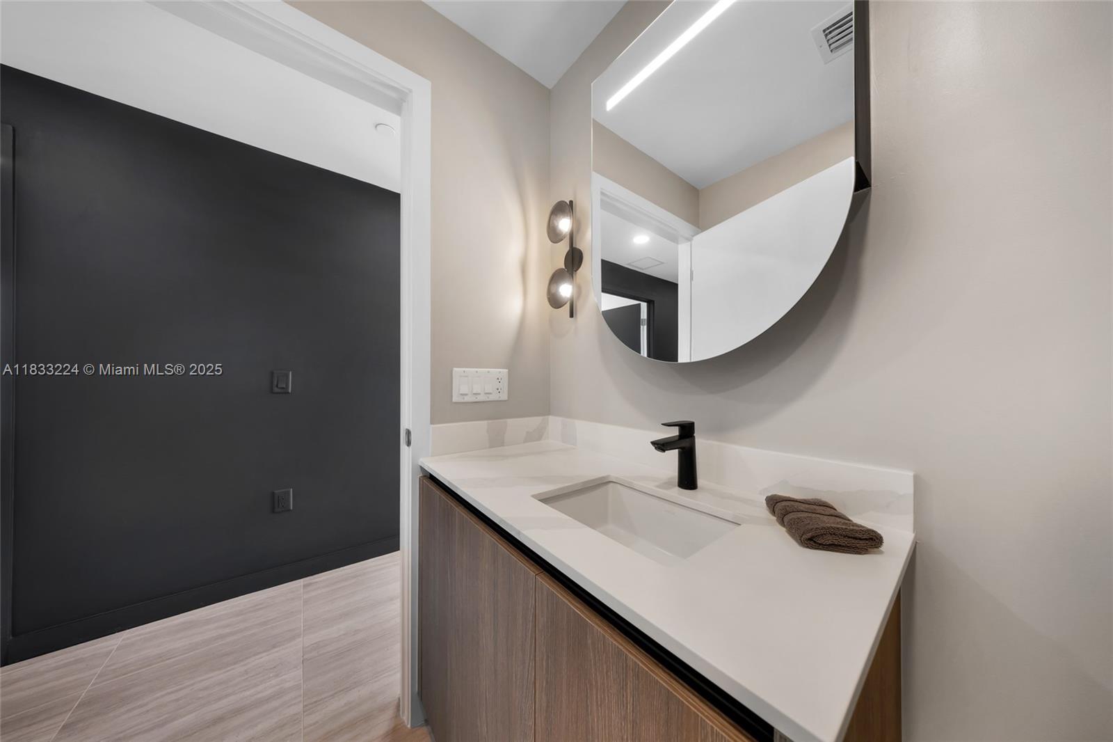 580 72nd Street, Unit 910 Miami Beach, FL 33141 - Photo 40 of 46 a bathroom with a sink and a mirror