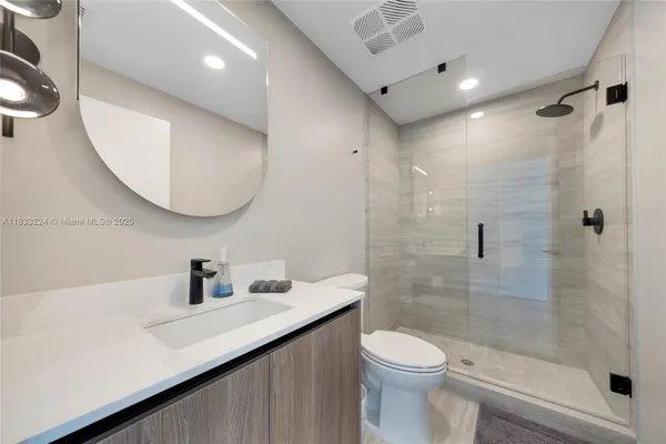 a bathroom with a sink a toilet and a mirror