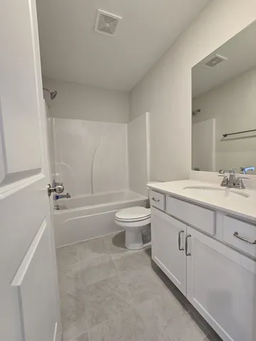 a bathroom with a granite countertop toilet a sink and a bathtub