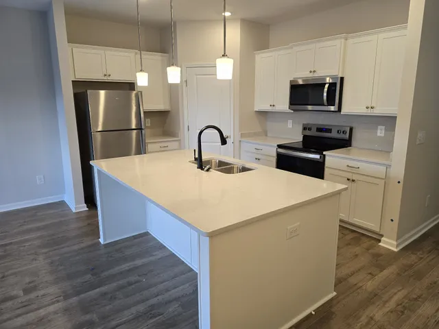 a kitchen with stainless steel appliances a refrigerator stove microwave and sink