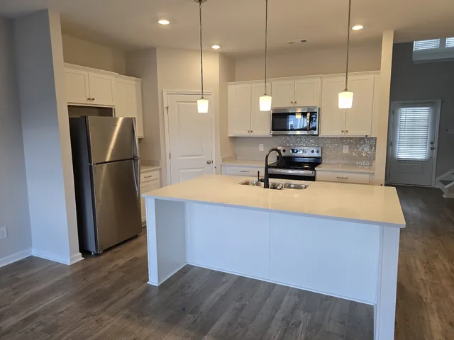 a kitchen with stainless steel appliances a refrigerator sink and microwave