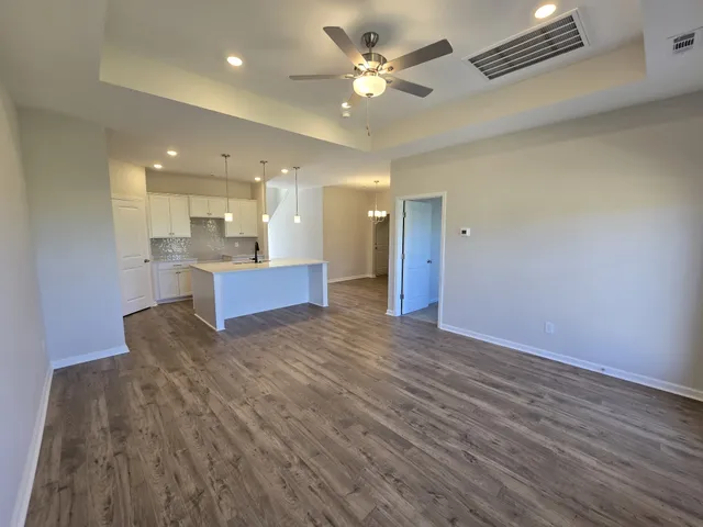 a view of kitchen and hall with wooden floor and a large window