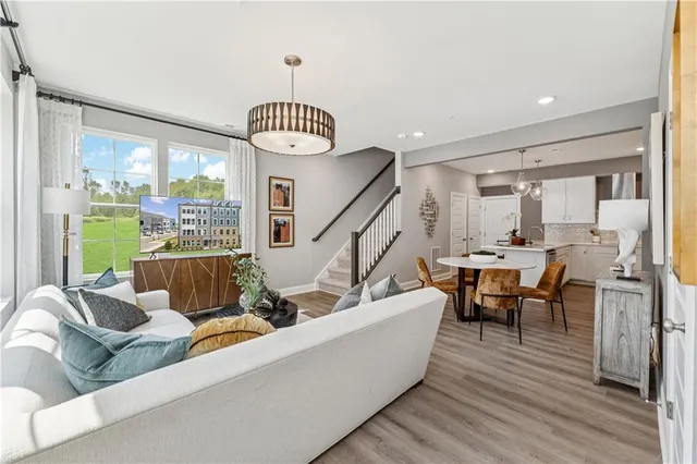 a living room with furniture floor to ceiling window and wooden floor