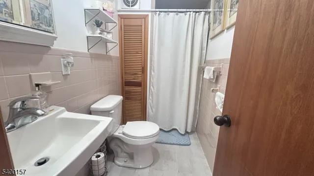 a bathroom with a sink a toilet and shower curtain