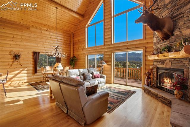 156 Paradiso Road Divide, CO 80814 - Photo 10 of 45 Living room featuring a wealth of natural light, Hickoty flooring, an inviting chandelier, and high vaulted ceiling