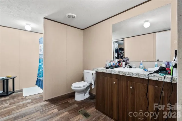 a bathroom with a granite countertop sink toilet and a mirror