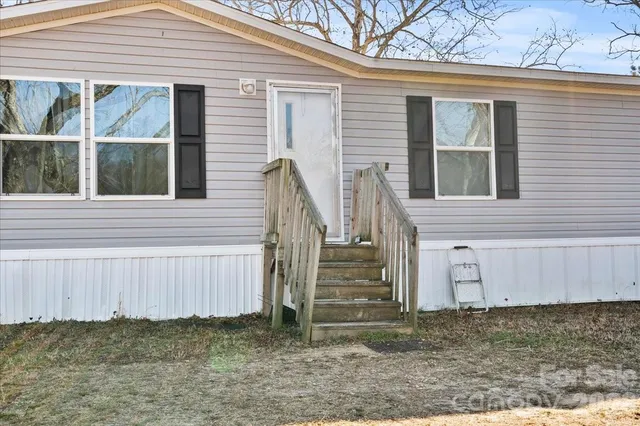 a view of a house with a small yard and wooden fence
