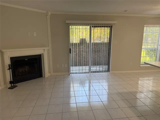 a view of an empty room with a fireplace and a window