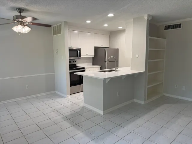 a kitchen with stainless steel appliances a sink stove and refrigerator