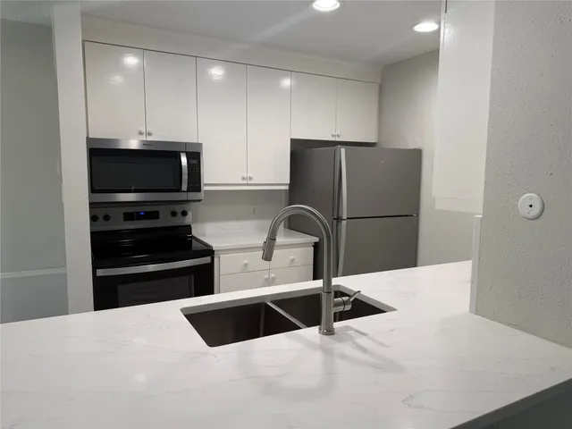 a kitchen with a refrigerator and a sink