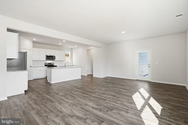 a view of kitchen with granite countertop cabinets and refrigerator