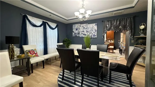 a view of a dining room with furniture a chandelier and wooden floor