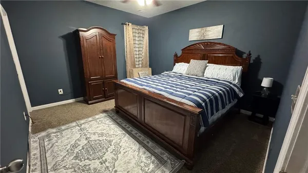 a bedroom with a bed and teddy bear on bed