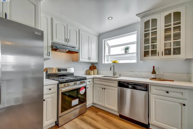 a kitchen with stainless steel appliances granite countertop a stove sink and cabinets