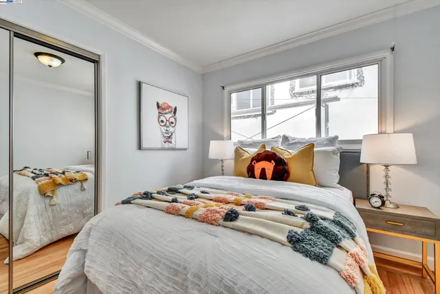 a bedroom with a bed and a lamp on dresser