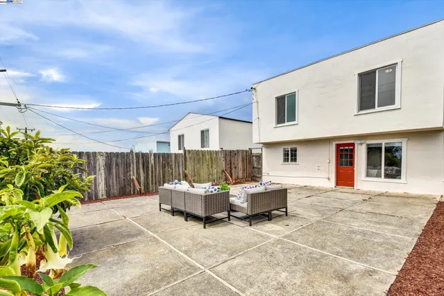 a view of a house with backyard and sitting area