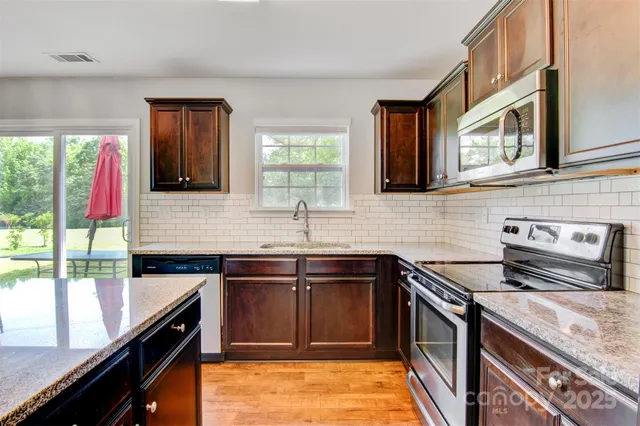 a kitchen with a sink stove top oven and cabinets