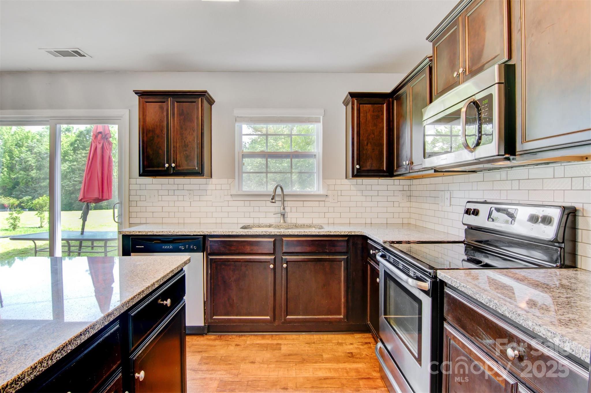 5311 Oakdale Ridge Road Charlotte, NC 28216 - Photo 15 of 35 a kitchen with a sink stove top oven and cabinets