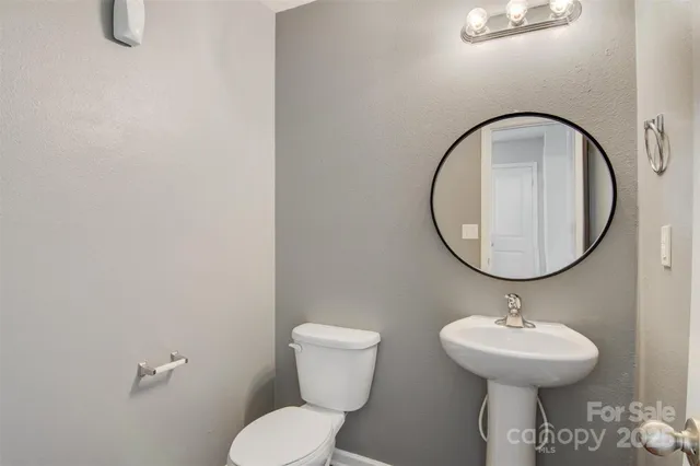 a bathroom with a toilet a sink and a mirror