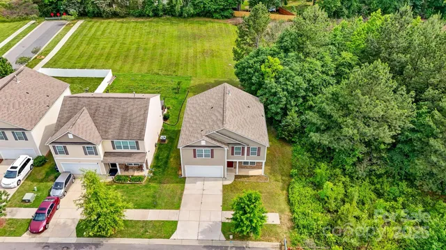 an aerial view of a house with swimming pool and garden
