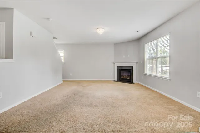 en empty room with windows and fireplace