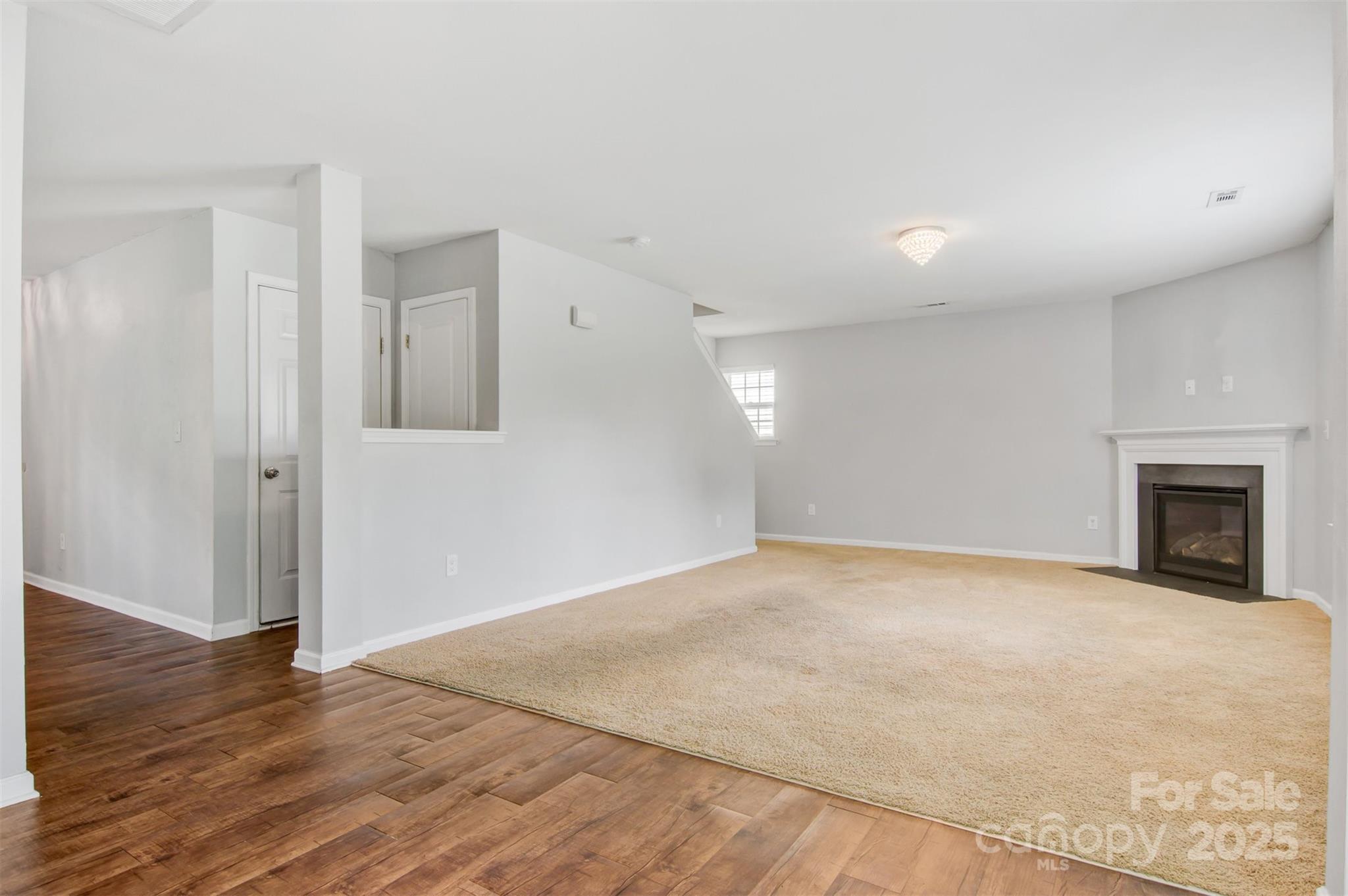 5311 Oakdale Ridge Road Charlotte, NC 28216 - Photo 10 of 35 a view of an empty room with wooden floor and a fireplace