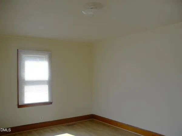a view of a small space with wooden floor and a window
