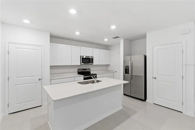 a kitchen with stainless steel appliances a refrigerator sink and cabinets