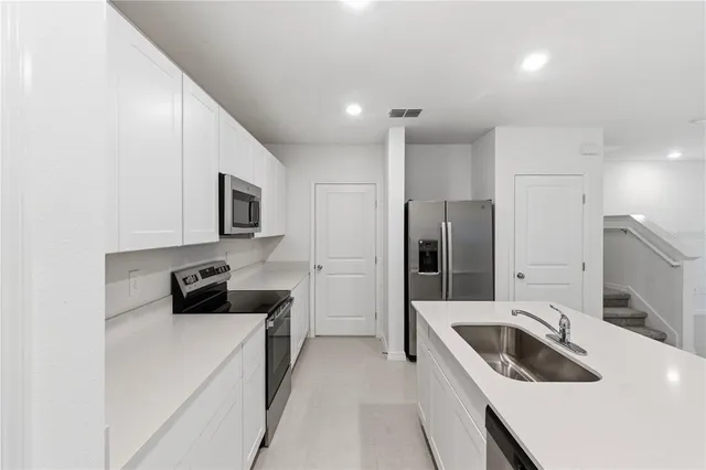 a kitchen with a sink stove and refrigerator