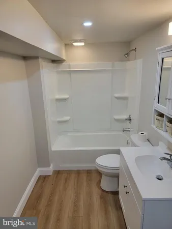 a bathroom with a sink a toilet and a large mirror