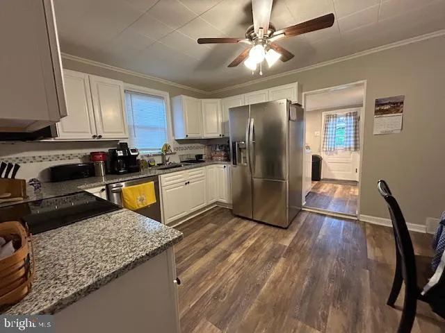 a kitchen with stainless steel appliances granite countertop a refrigerator a stove a sink and a microwave