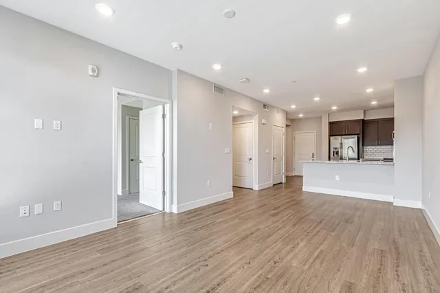 a view of an empty room with wooden floor