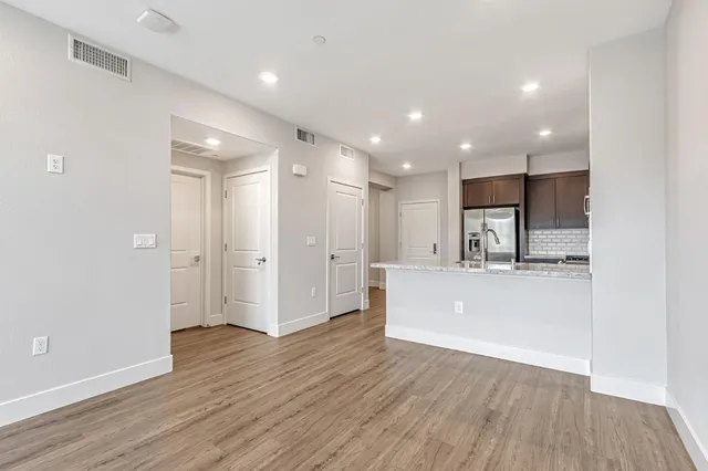 a view of kitchen with refrigerator stove and wooden floor