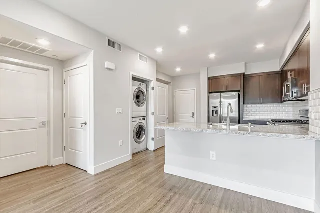 a large kitchen with a center island stainless steel appliances and cabinets