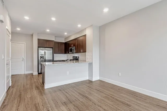 a view of kitchen with stainless steel appliances refrigerator microwave and stove