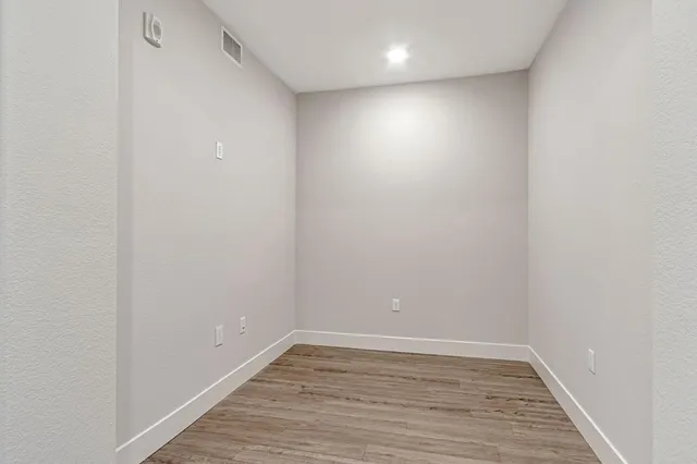 a view of an empty room with wooden floor