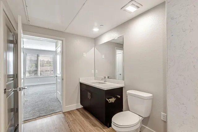 a bathroom with a granite countertop sink toilet a mirror and a shower