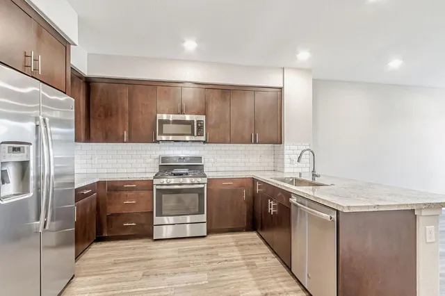 a kitchen with stainless steel appliances granite countertop a sink and stove top oven