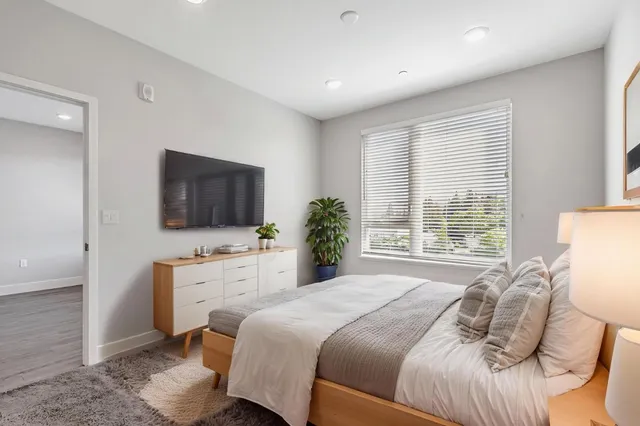 a bedroom with a bed and a flat screen tv