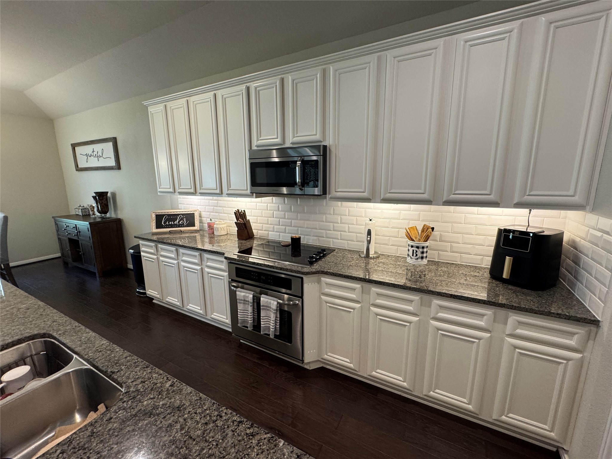 4507 Axis Trail Conroe, TX 77303 - Photo 11 of 34 a kitchen with stainless steel appliances granite countertop a sink a stove and a microwave
