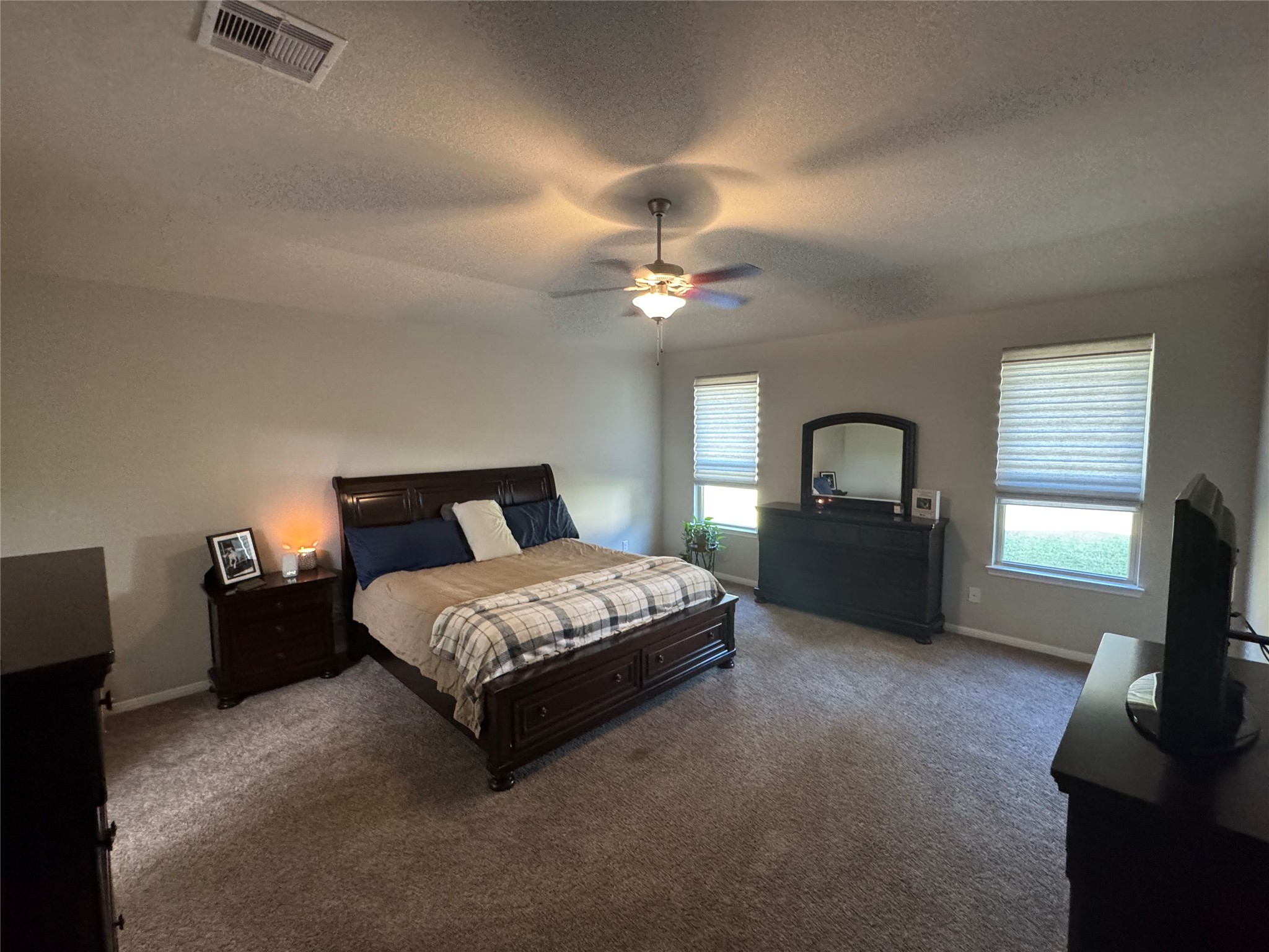 4507 Axis Trail Conroe, TX 77303 - Photo 15 of 34 a spacious bedroom with a bed and a tv
