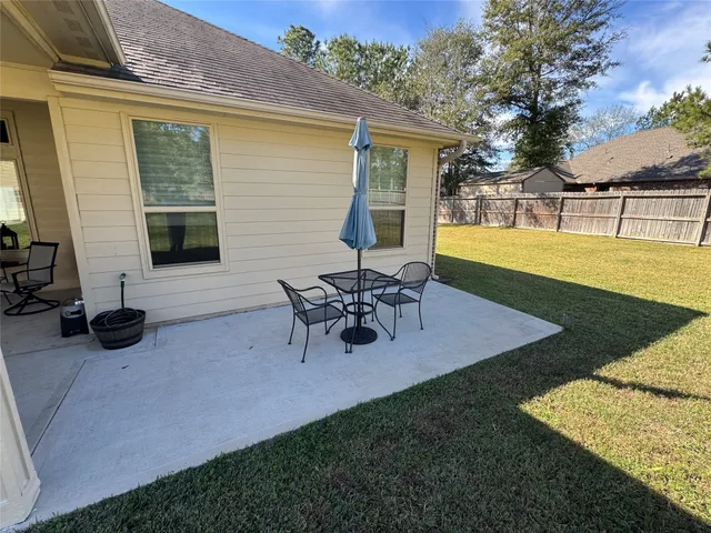 a view of a house with patio and a yard