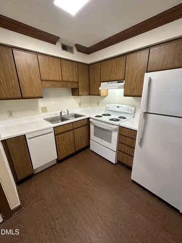 a kitchen with sink cabinets and white appliances